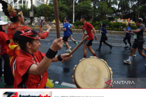 Suporter memainkan perkusi untuk menyemangati pelari Jakarta Running Festival.