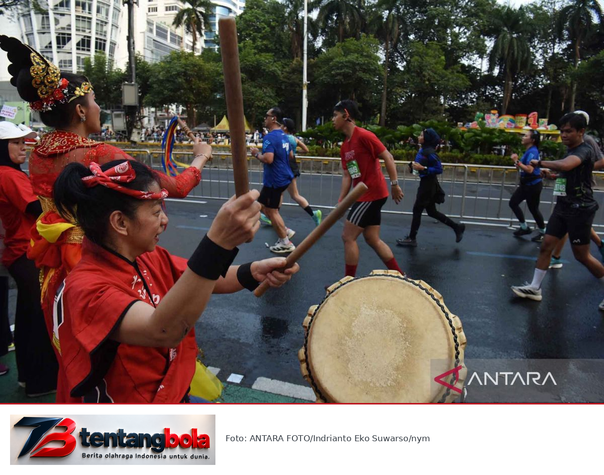 Suporter memainkan perkusi untuk menyemangati pelari Jakarta Running Festival.