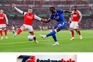 Pemain Everton berseragam biru menendang bola di antara pemain Arsenal.